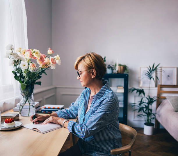 istock A Serious Beautiful Senior Woman With Glasses Writing Her Diary 1427370083