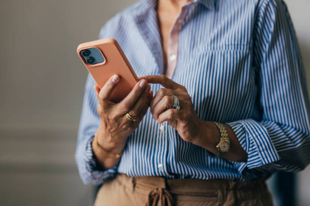 An Unrecognizable Businesswoman Texting Somebody Using Her Mobil