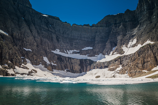 Iceberg Lake appears a beautiful teal color as a result of the minerals in the water caused by erosion.