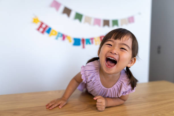 彼女の誕生日に家で笑う幸せな女の子 - child facial expression asian and indian ethnicities asia ストックフォトと画像
