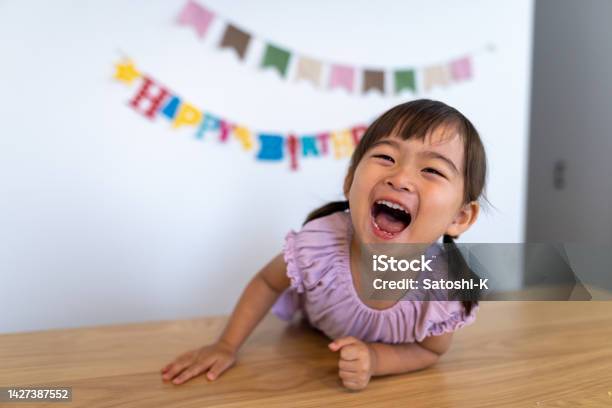 Happy Girl Laughing At Home On Her Birthday Stock Photo - Download Image Now - Child, Smiling, Japanese Ethnicity