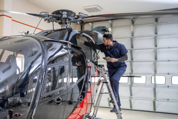 istock Air vehicle mechanic in uniform standing on ladder and looking into jet, front side view 1427393990
