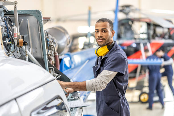 istock Aviation engineer wearing uniform working in helicopter hangar, mid shot 1427393998