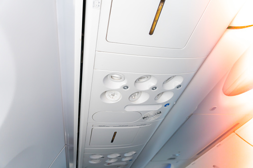 Console panel in a aircraft fuselage cabin. The air condition and light on plane panel above passangers. lamp above the low cost airline seat
