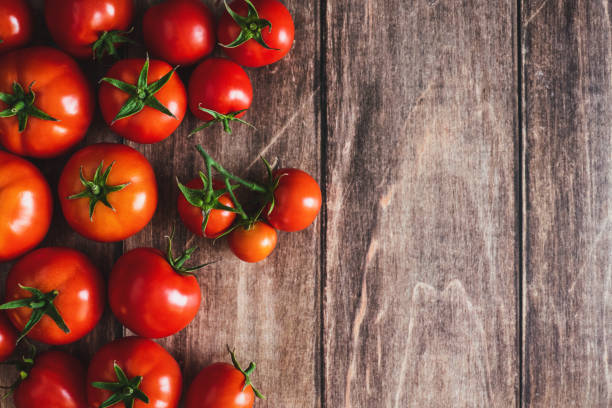 istock Tomatoes on wooden background, freshly picked red tomato fruit frame, cooking background, copy space 1427404973