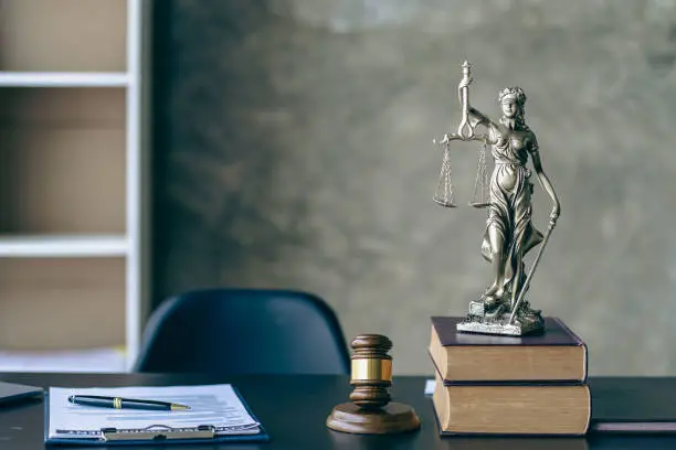 Photo of The scales of injustice, the hammer of the law tiger skin judges on the table in the conceptual law office.