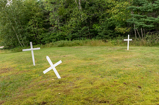 Three white wooden crosses are spread out in an old pioneer cemetery in the small town of Wawa, Ontario.