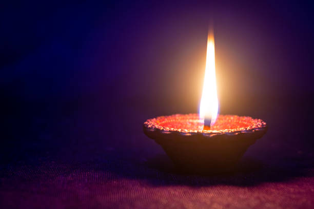 istock Happy Diwali - Clay diya lamp lit during diwali celebration 1427439539
