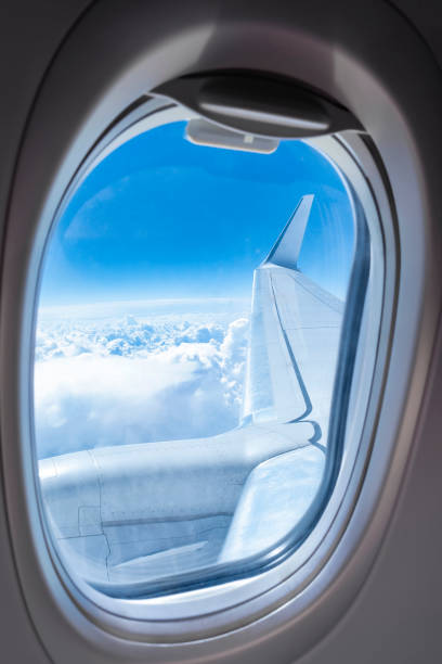 istock Porthole overlooking the blue sky and clouds. Airplane window. 1427442377