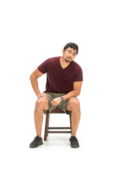 Side view of a young girl sitting on chair with arms crossed look at the bottom on white background