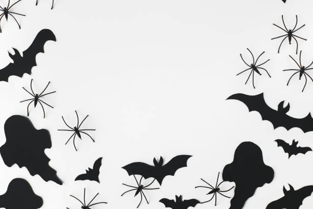 istock Halloween flat lay. Black ghosts, spiders and bats decorations on white background. Happy Halloween! Card template with space for text. Stylish minimal frame 1427445285