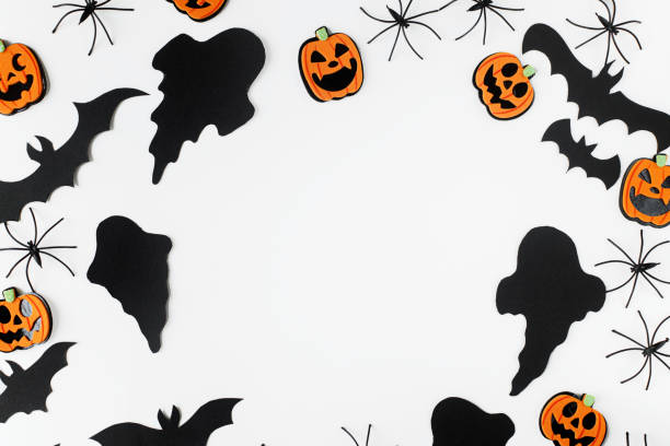 istock Halloween flat lay. Black ghosts, spiders, bats and orange pumpkins decorations on white background. Happy Halloween! Card template with space for text. Stylish frame composition 1427445314