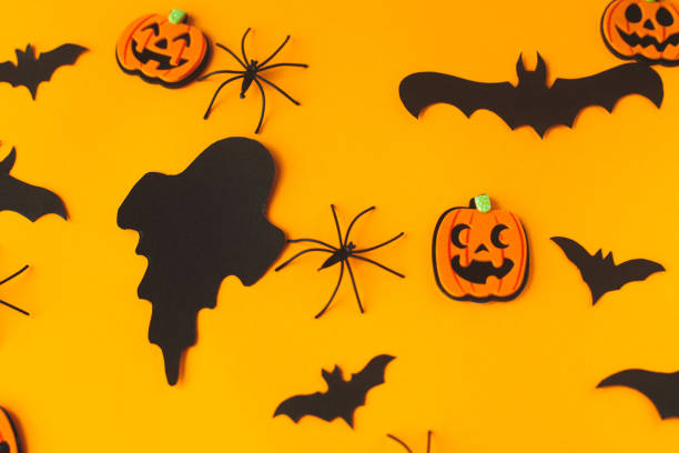 istock Happy Halloween! Black ghosts, spiders, bats and pumpkins decorations on orange background flat lay. Card template. Stylish halloween still life 1427447028