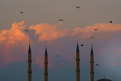 Four minarets of a mosque under cloudy sky, with copy space