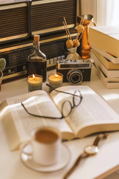 Open book, glasses, coffee and candles on the table