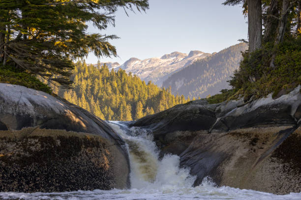 istock Small waterfall draining a lake with mountain scenery, Inside Passage, British Columbia. 1427452043
