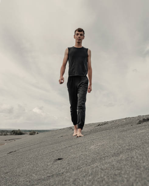 istock Young man walking alone on sand in sandy desert 1427459232