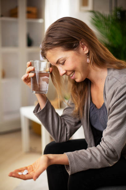 istock Young woman drinking medicine having fever 1427465397