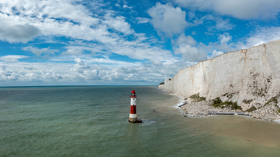 view of the Beachy Head Lighthouse in the English Channel with the white cliffs of the Seven Sisters in the background