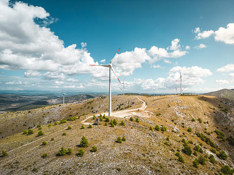 Aerial drone view of wind turbines generating renewable energy for green and sustainable future. Shot on the cost of Croatia.