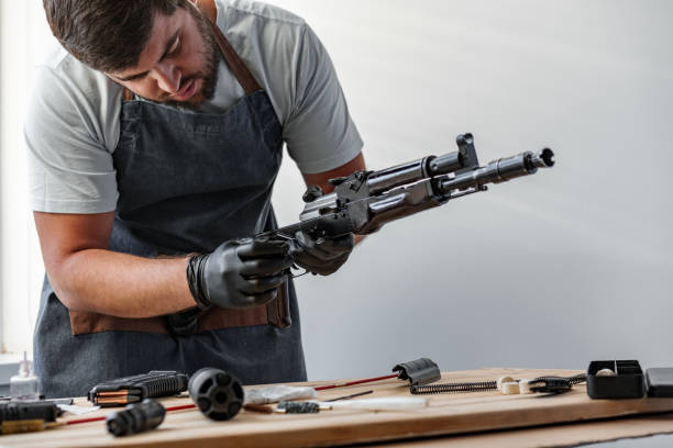 istock Close up of young man in apron disassembling a gun above the table 1427474669
