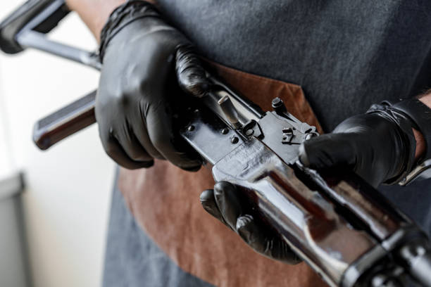 istock Close up of young man in apron disassembling a gun above the table 1427475163
