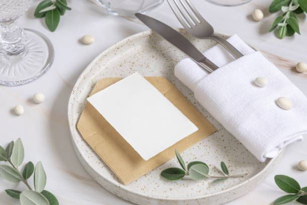 istock Elegant Table setting with a card decorated with eucalyptus branches close up, Wedding mockup 1427481056