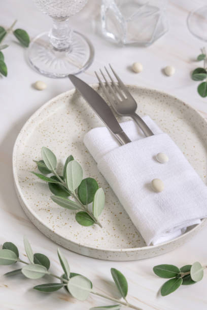 istock Elegant wedding Table setting decorated with eucalyptus branches and white pebbles close up 1427481061