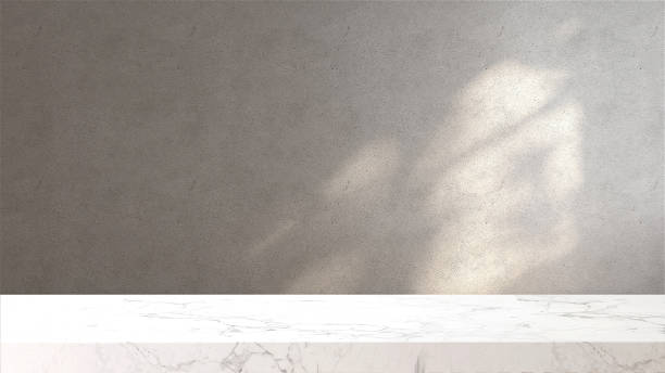 plateau ou comptoir en marbre blanc dans un loft, salle murale en béton moderne et minimale avec lumière du soleil et ombre d’arbre de la fenêtre à la maison - table photos et images de collection