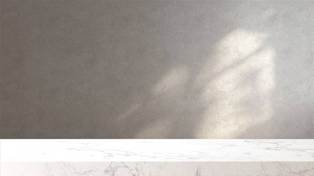 다락방의 흰색 대리석 탁상 또는 조리대, 집에서 창문에서 햇빛과 나무 그림자가있는 현대적이고 최소한의 콘크리트 벽면 - 근거리 초점 뉴스 사진 이미지
