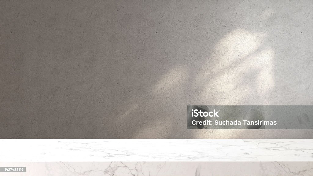 White marble tabletop or countertop in loft, modern and minimal concrete wall room with sunlight and tree shadow from window at home White marble tabletop or countertop in loft, modern and minimal concrete wall room with sunlight and tree shadow from window at home for household and personal product display Backgrounds Stock Photo