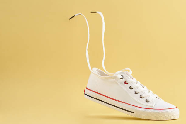 istock White casual sneakers on yellow background, creative minimalism 1427483334