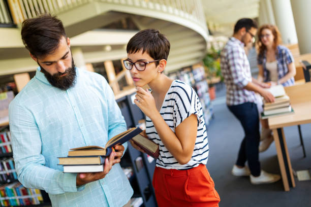 istock Happy university students studying with books in library. Group of multiracial people in college 1427487980