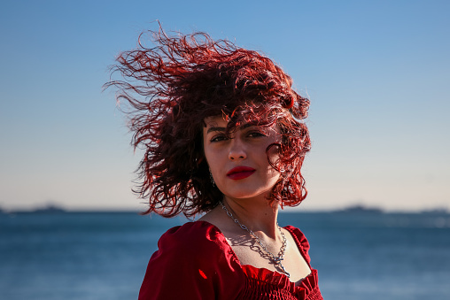 Red-haired woman with her hair dancing in the wind