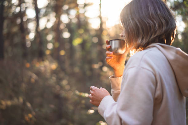istock young woman drinking tea in a pine forest 1427494494