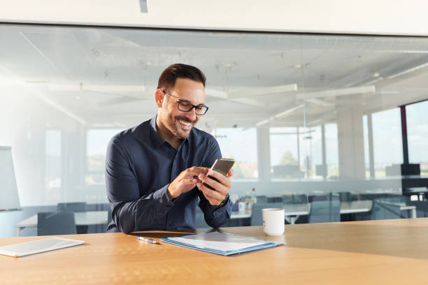 istock Happy businessman using mobile phone in the office. 1427495427