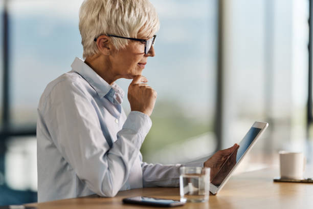 istock Pensive senior businesswoman using touchpad in the office. 1427496076
