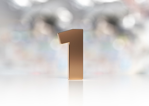 Golden number one is standing on the white desk in front of the bokeh background horizontal composition