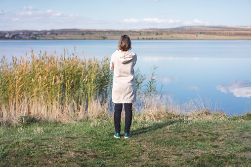 young woman standing in front of a lake