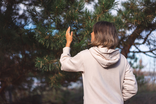 young woman walking in a pine forest park