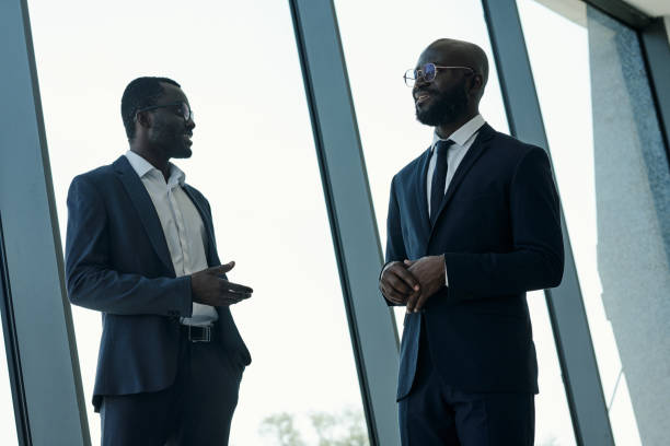 istock Two young confident business partners in elegant suits discussing working points 1427499233