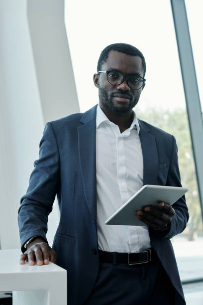 istock Young confident broker or chief executive officer in elegant suit using tablet 1427499283