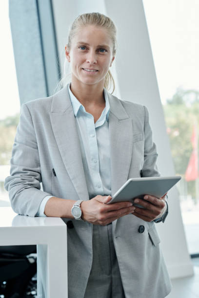 istock Young smiling broker or office manager in grey suit learning online data 1427499288