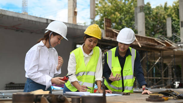 istock Team of engineers and managers and construction workers discussing plan details at the construction site. 1427499717
