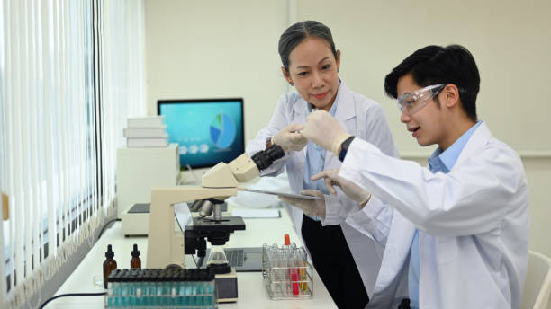 istock Professional scientists team conducting experiments, consisting of glassware test tubes and microscopes in laboratory. 1427499818