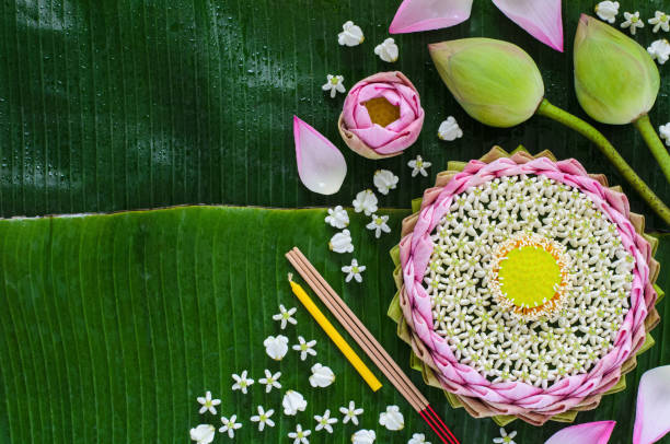 Pink lotus petal krathong decorates with its pollen, crown flower, incense stick and candle Pink lotus petal krathong decorates with its pollen, crown flower, incense stick and candle for Thailand Full moon or Loy Krathong festival on banana leaves background. krathong stock pictures, royalty-free photos & images