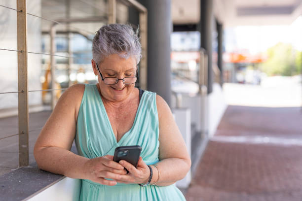 istock Senior woman using a mobile phone outdoors 1427501762