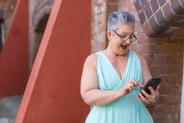 istock Senior woman using a mobile phone outdoors 1427501766