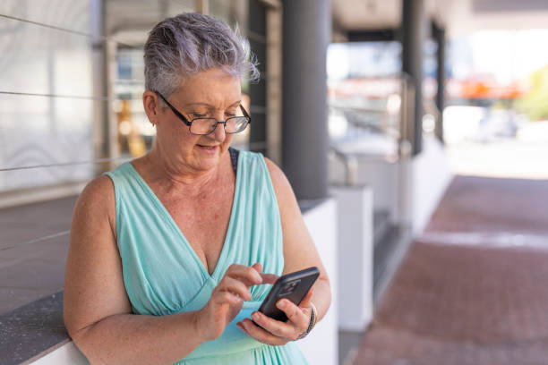 istock Senior woman using a mobile phone outdoors 1427501768