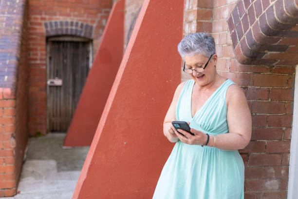 istock Senior woman using a mobile phone outdoors 1427501777